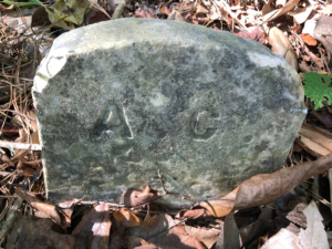gravestone marked with the initials "A C"